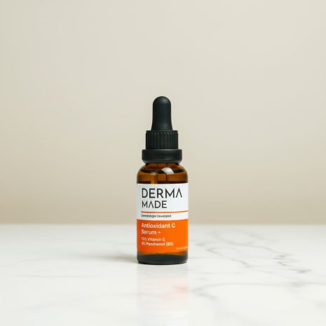Derma Made Antioxidant C Serum + with Vitamin C and B5 on Marble Counter Derma Made Antioxidant C Serum + bottle with 15% Vitamin C and 5% Panthenol (B5) displayed on a white marble counter against a neutral beige background.