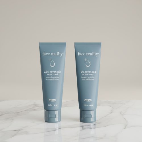 High-quality product photo of Face Reality Acne Med 2.5% and 5% Benzoyl Peroxide acne treatments standing side by side on a marble surface. Dermatologist-developed formulas designed to clear acne and prevent breakouts.