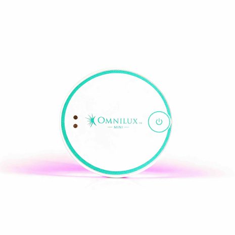 Omnilux Mini Blemish Eraser LED device for acne treatment shown glowing with therapeutic light